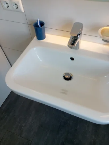 Moderner Waschbecken mit Wasserhahn in einem hellen Badezimmer.